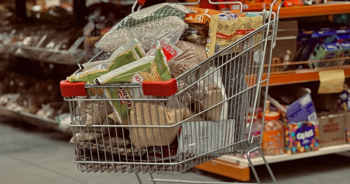 A grocery cart being filled in a supermarket aisle in Canada