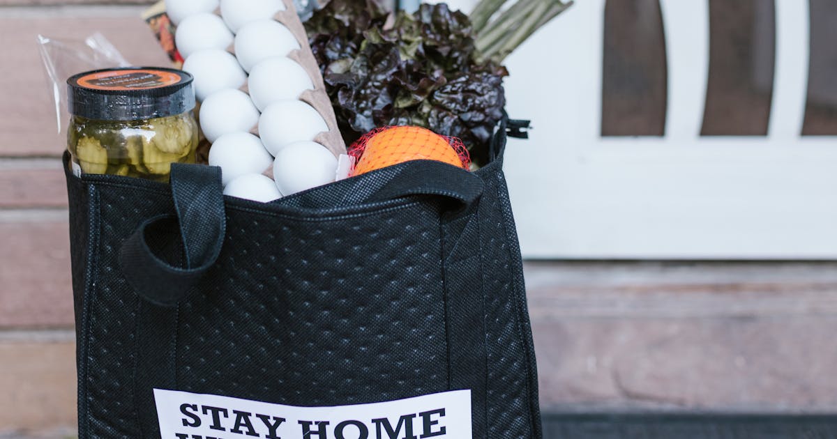 Grocery delivery bags on a doorstep representing online shopping costs